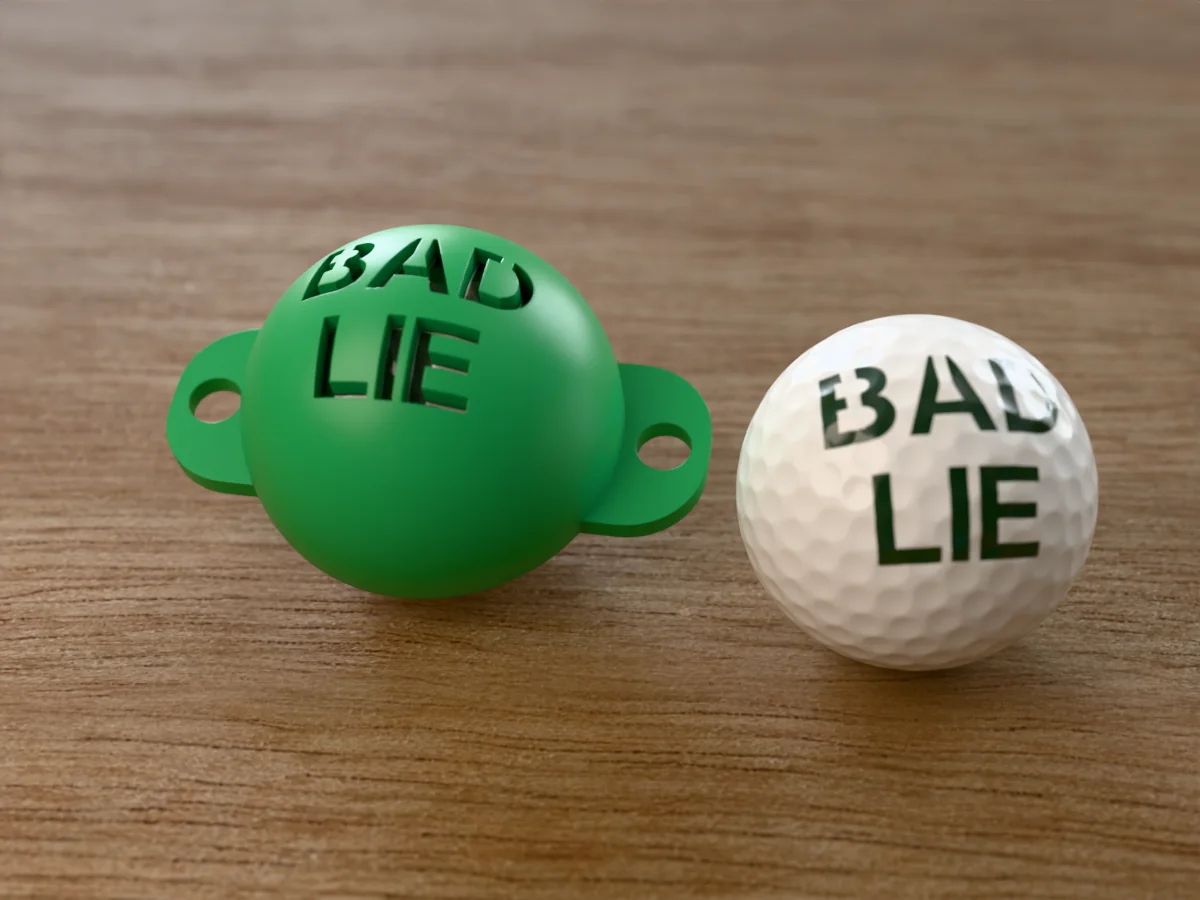 3D render of a green 3D-printed golf ball stencil with BAD LIE cut through it, sitting on a golf ball, next to a ball marked with BAD LIE in green
