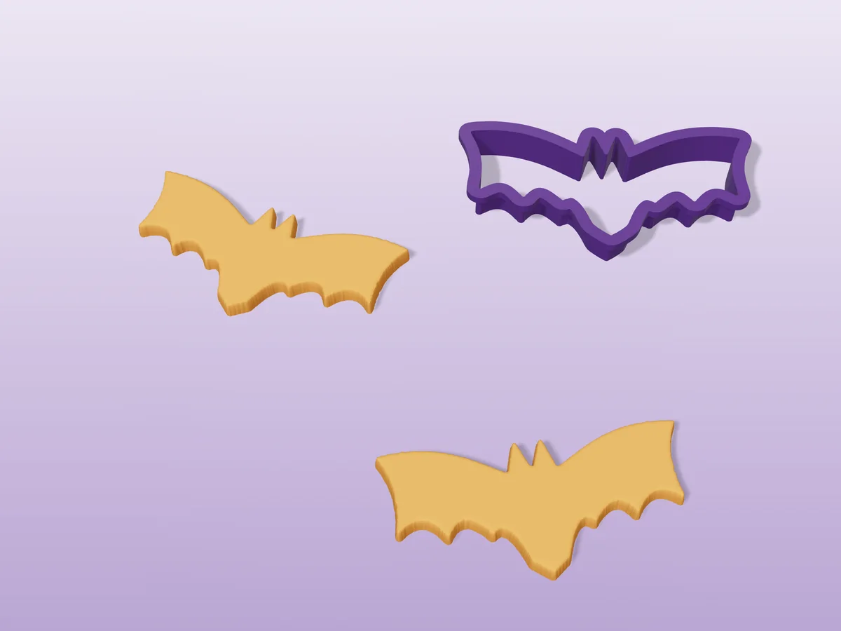 3D render of a purple 3D-printed bat cookie cutter next to two golden baked cookies in the same shape