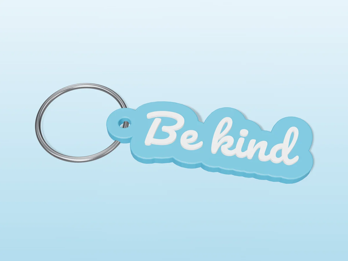 3D render of a sky blue and white 3D-printed Be kind keychain with a steel split ring through its hole