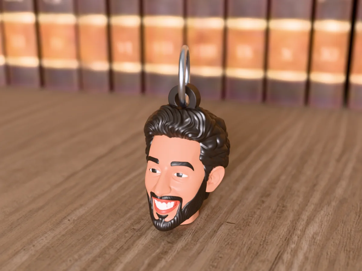 3D render of a 3D-printed head keychain of a guy with short black hair and a trimmed black beard, painted in 5 colours, on a table