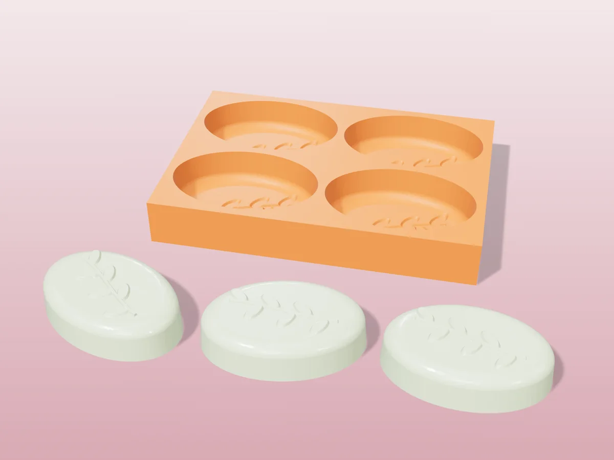 3D render of a printed orange tray with four oval soap cavities, and three pale green soaps with a raised leaf sprig in front
