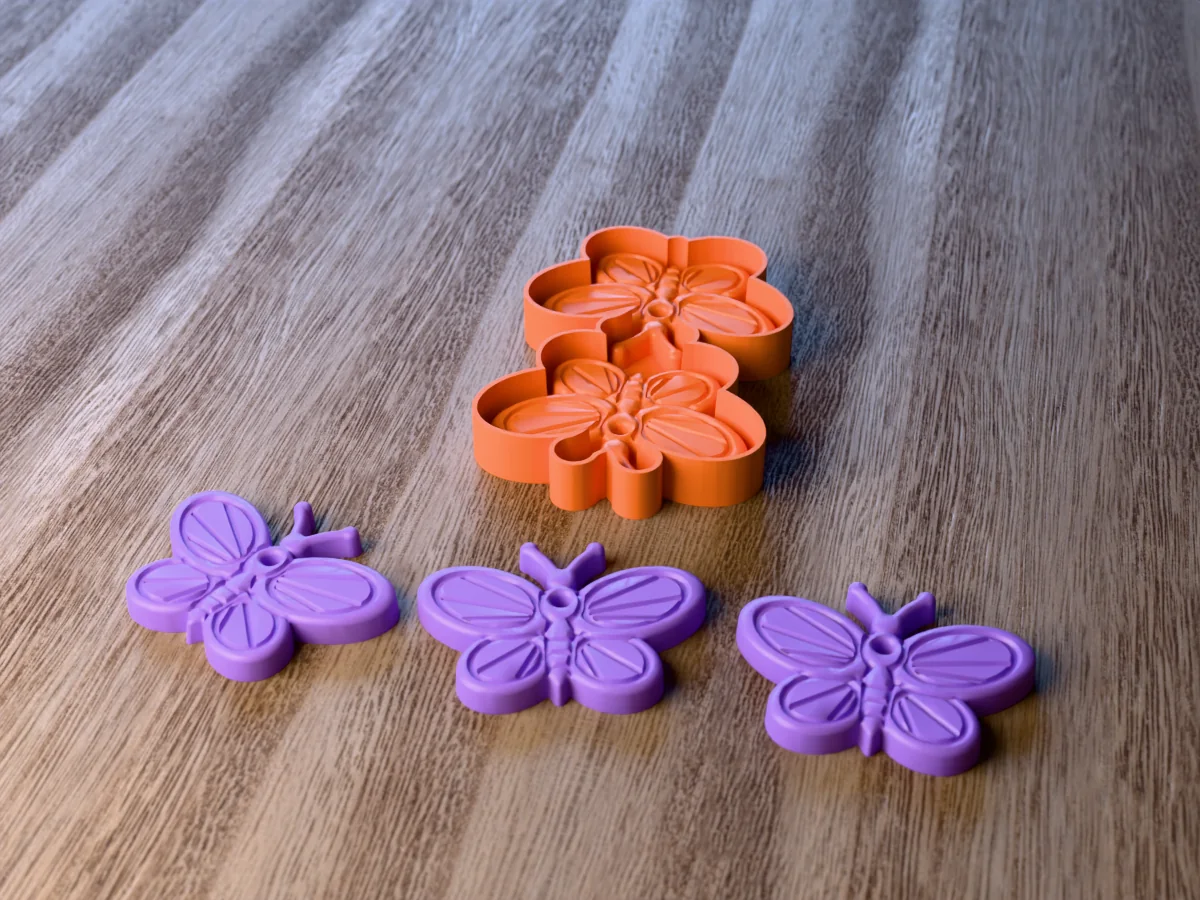 3D render of the printed caster for a two-cavity butterfly freshie mold, with three purple butterfly car freshies with veined wings in front