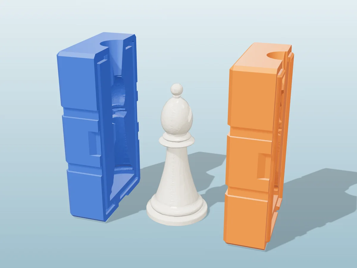 3D render of an ivory resin chess bishop with its slit mitre between the two printed halves of its rigid orange and blue mold