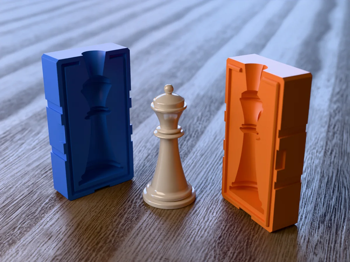 3D render of an ivory resin chess queen with a turned coronet and ball between the two printed halves of its rigid orange and blue mold