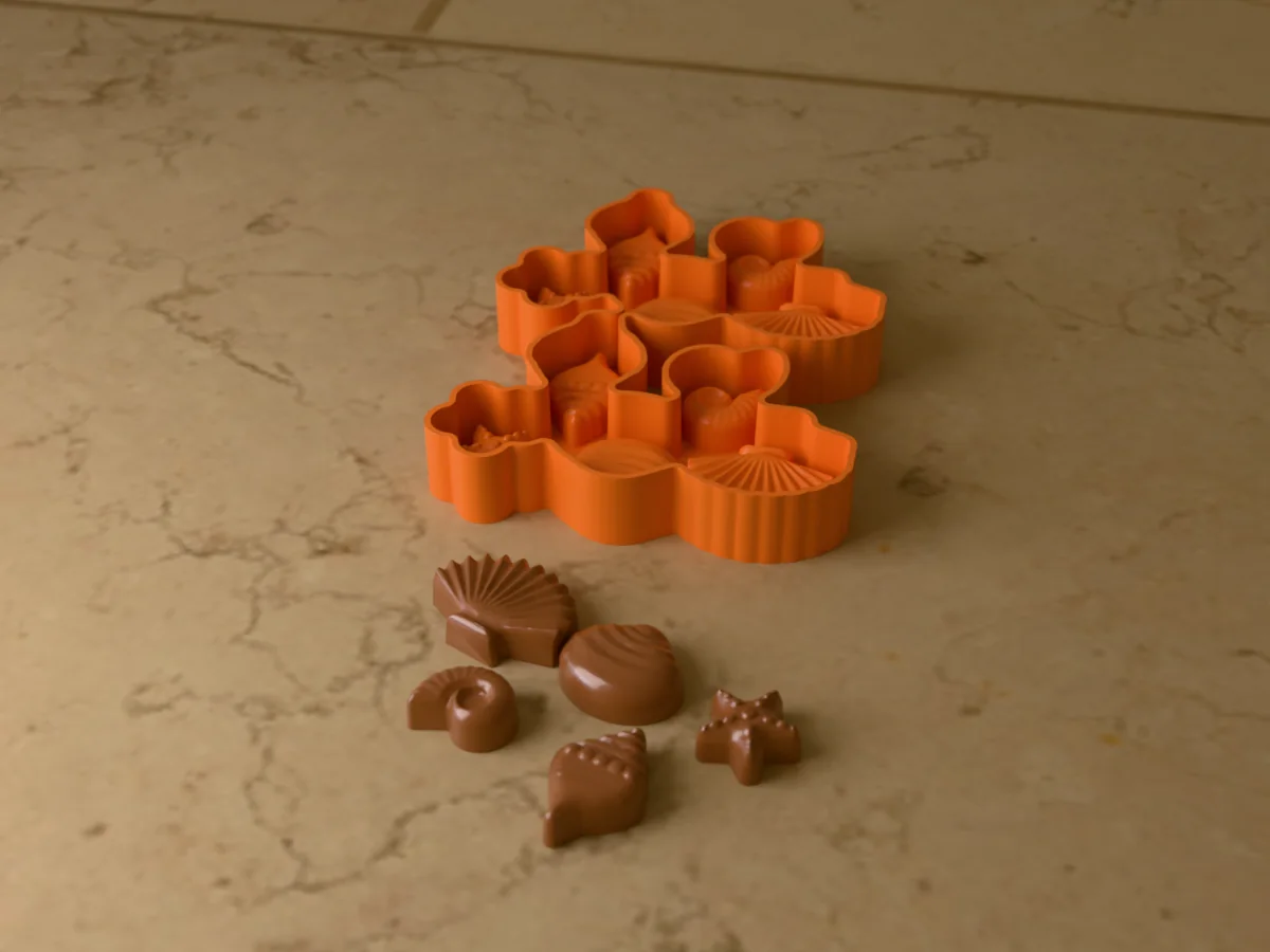 3D render of the printed caster for a silicone chocolate seashell mold, with a scallop, clam, starfish, ammonite and whelk in chocolate in front