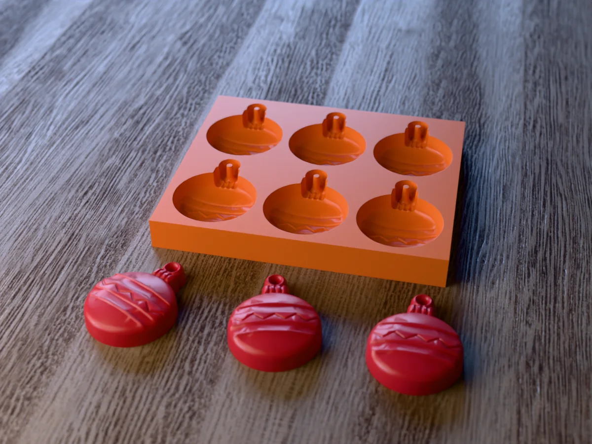 3D render of a printed orange tray with six Christmas bauble cavities, and three red bauble wax melts with a zigzag band, a cap and a loop in front