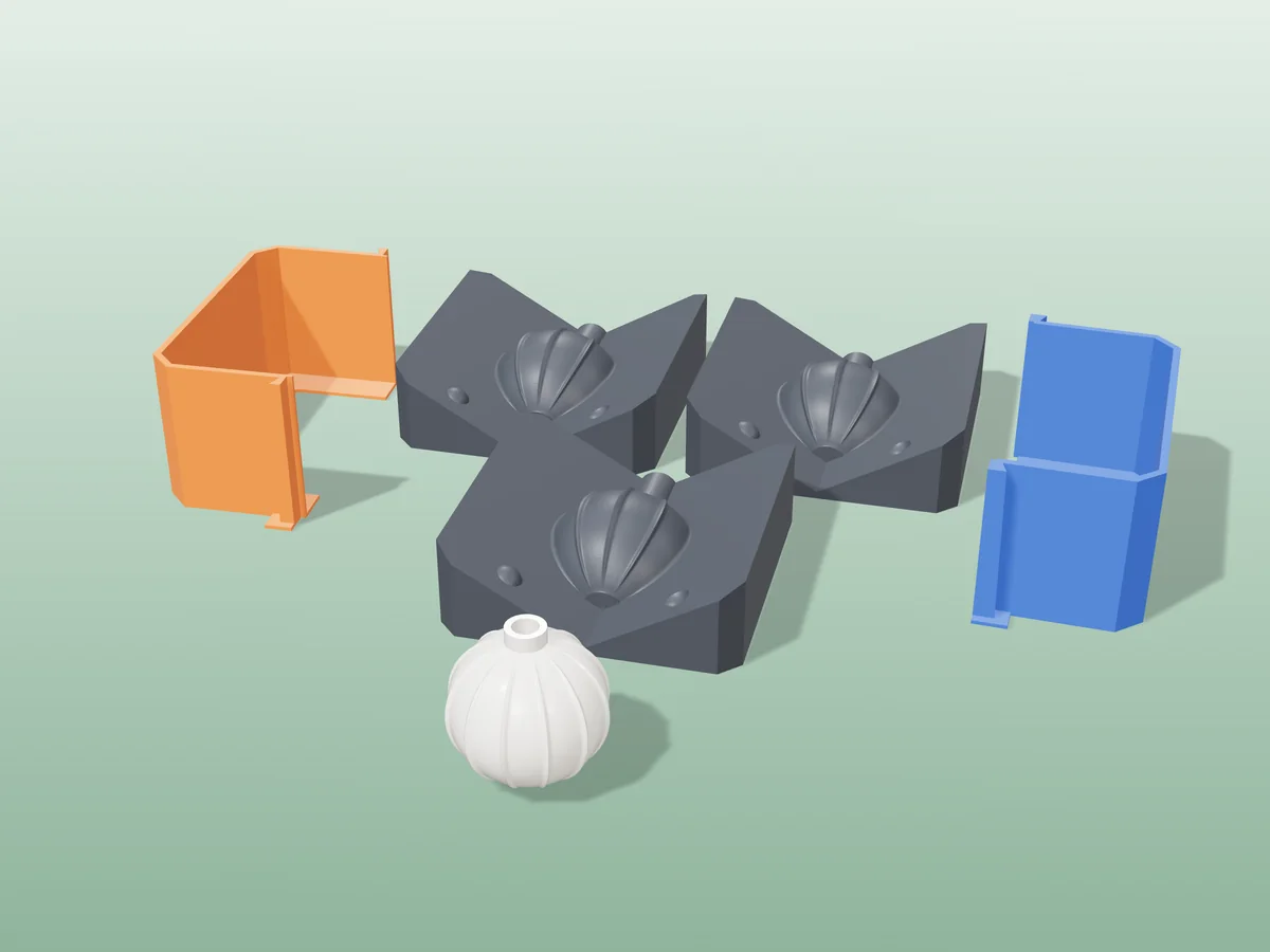 3D render of three printed plaster-mold housings for a ribbed Christmas ornament, orange and blue shells beside charcoal bases, with a white fired ribbed bauble in front