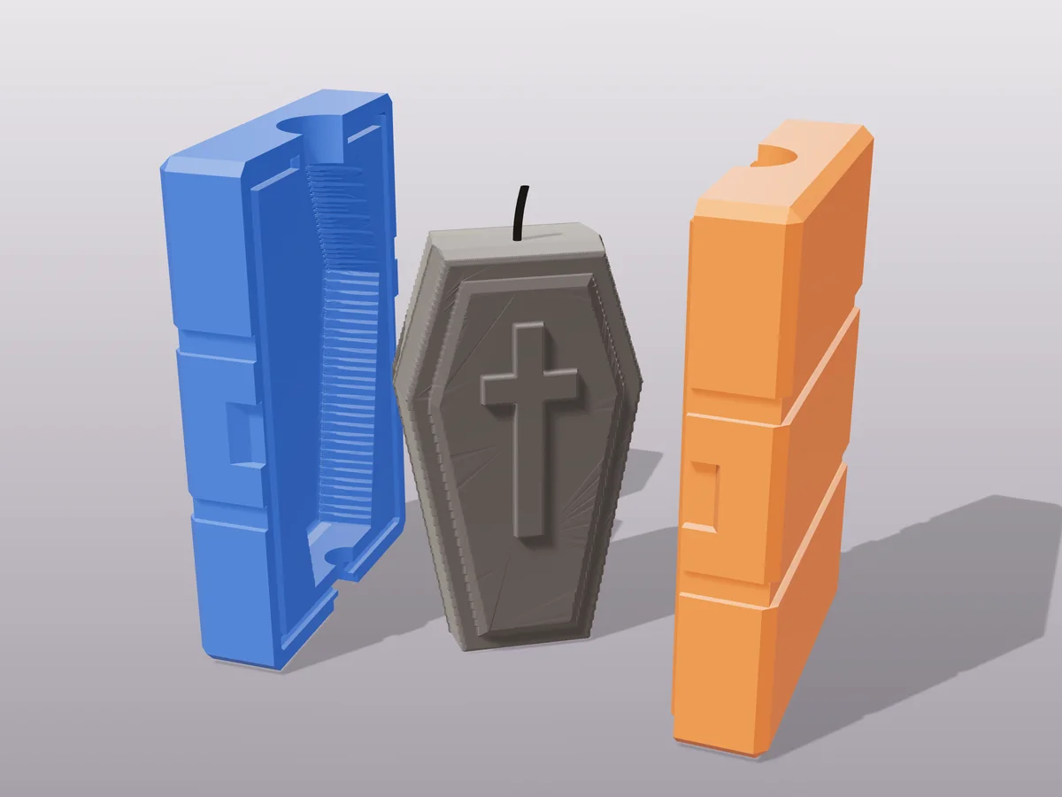 3D render of a black coffin candle with a cross on the lid between the two printed halves of its rigid blue and orange mold