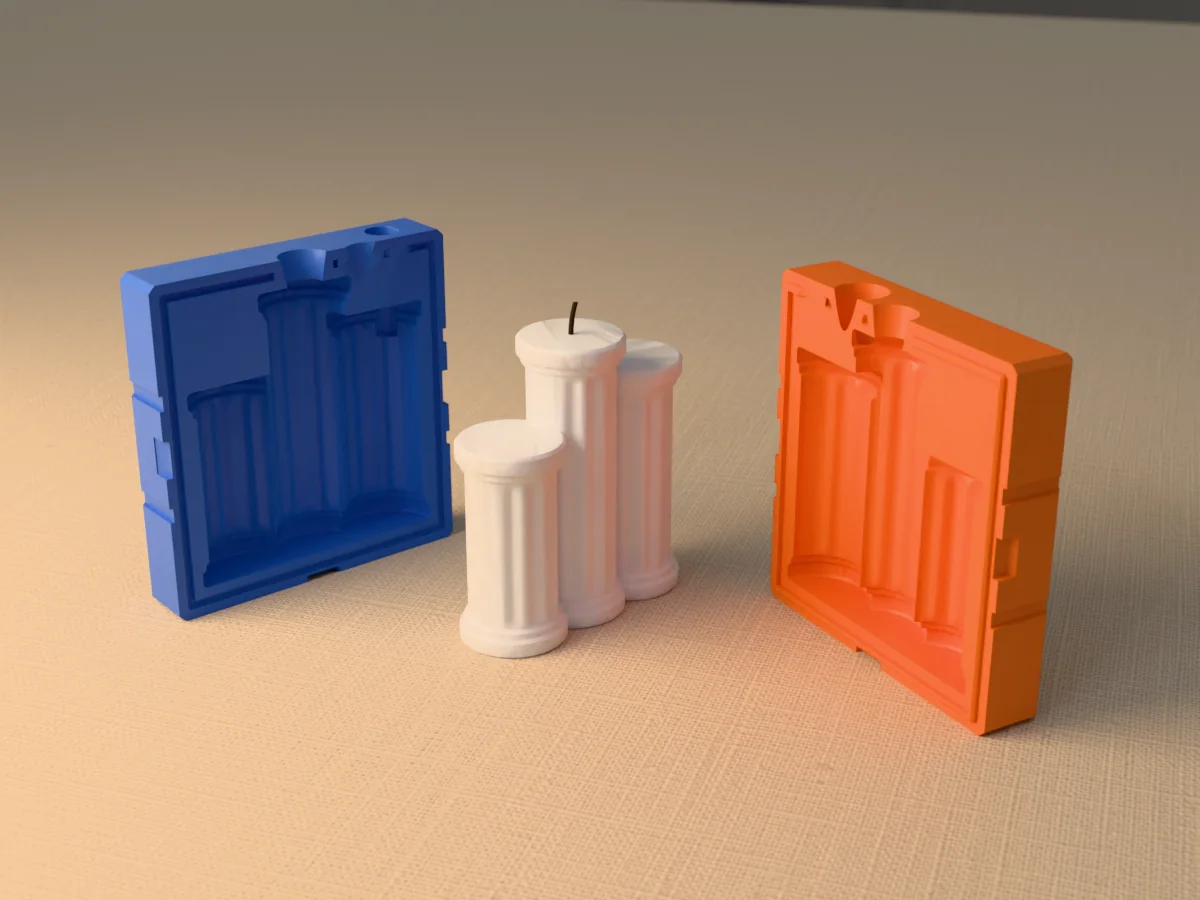 3D render of a white candle of three fluted Greek columns of different heights between the two printed halves of its rigid blue and orange mold