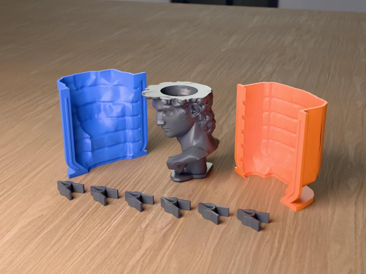 3D render of the classical David head planter master with its hollowed crown, fused on its printed charcoal base between the orange and blue shell halves, with the charcoal clamps in front