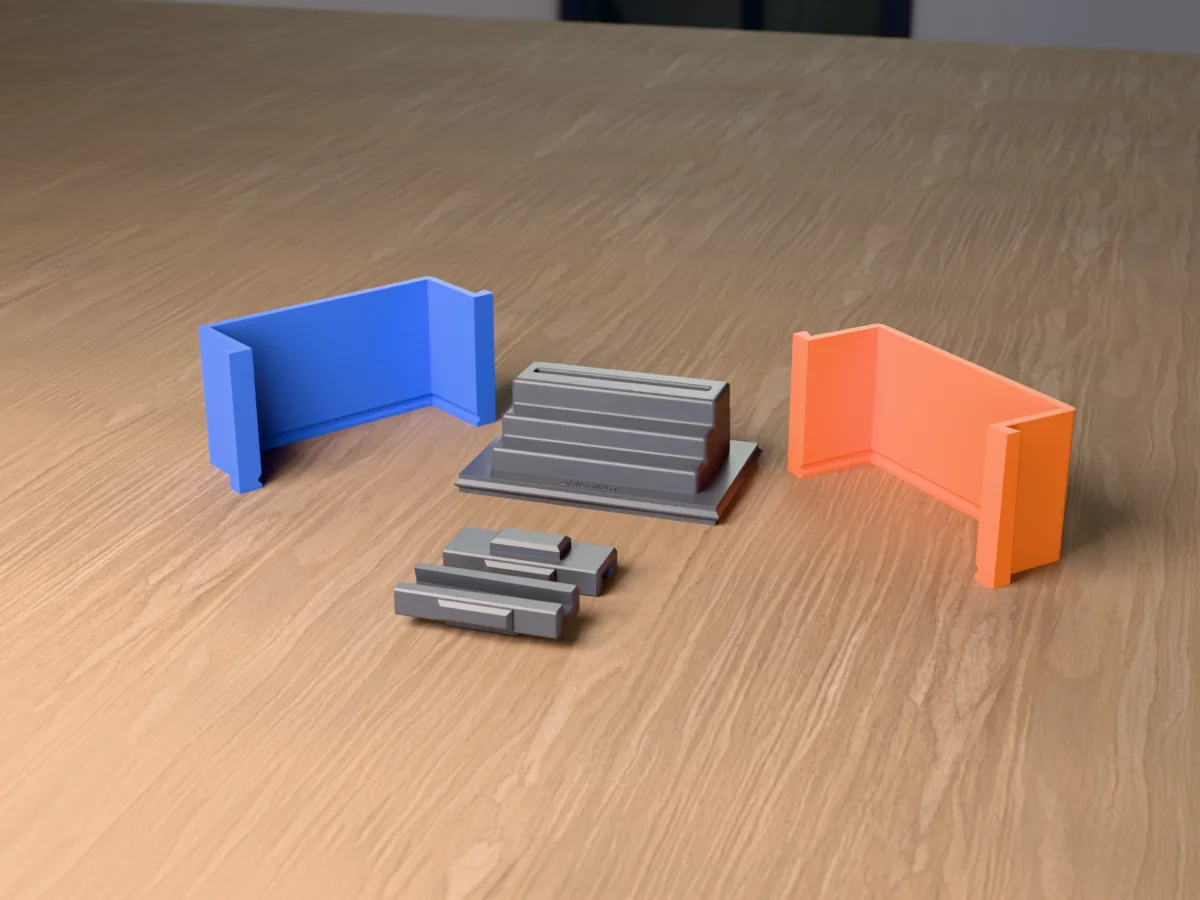 3D render of the concrete staircase card holder master, three steps with a slot on the top one, fused on its printed charcoal base between the orange and blue walls, with the charcoal clamps in front