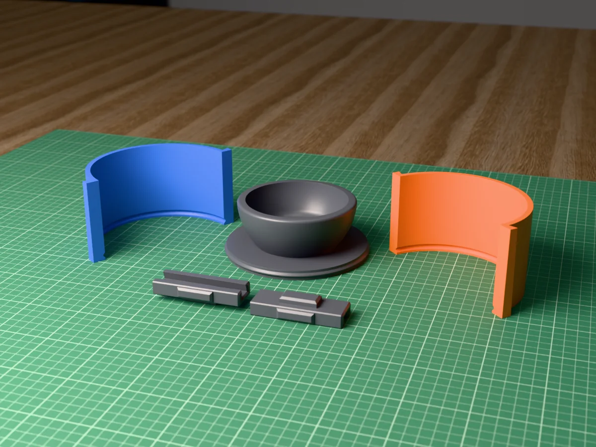 3D render of the low succulent bowl master fused on its printed charcoal base, between the orange and blue round walls, with the charcoal clamps behind