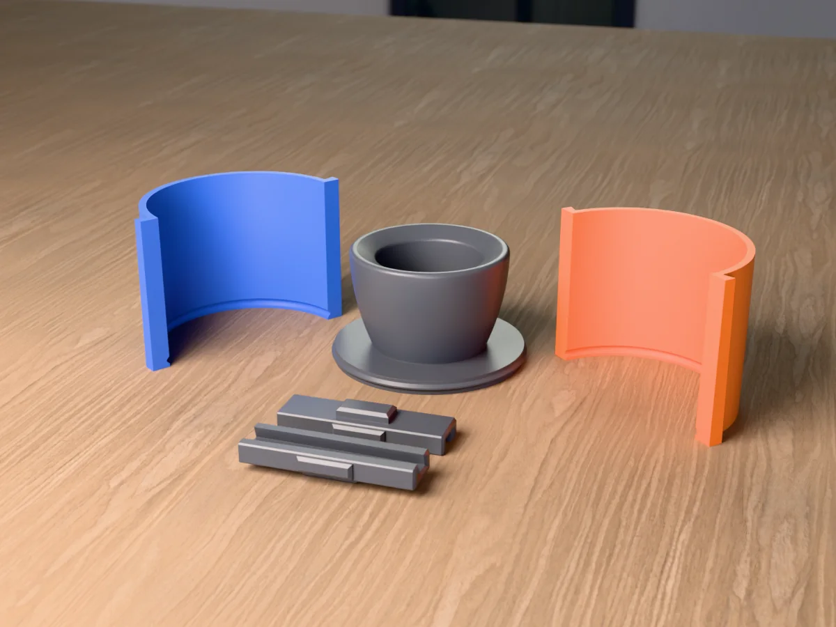 3D render of the concrete tabletop fire bowl master with its round can pocket, fused on its printed charcoal base between the orange and blue round walls, with the charcoal clamps in front