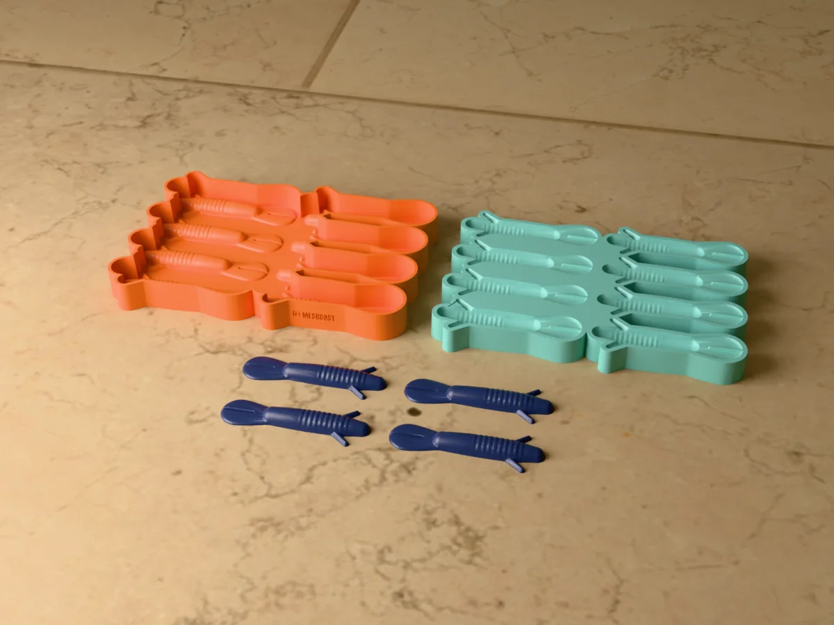 3D render of the printed caster for an eight-cavity silicone creature bait lure mold beside the silicone mold it pours, with dark blue soft plastic creature baits in front