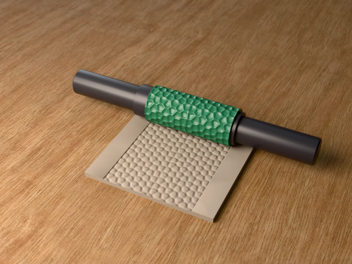 3D render of the printed crocodile skin textured rolling pin, its patterned sleeve between two dark handles, resting on a slab of clay it has pressed with crocodile scutes