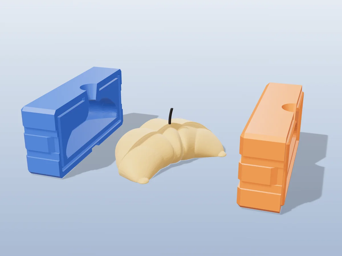 3D render of a golden croissant candle with rolled layers between the two printed halves of its rigid blue and orange mold