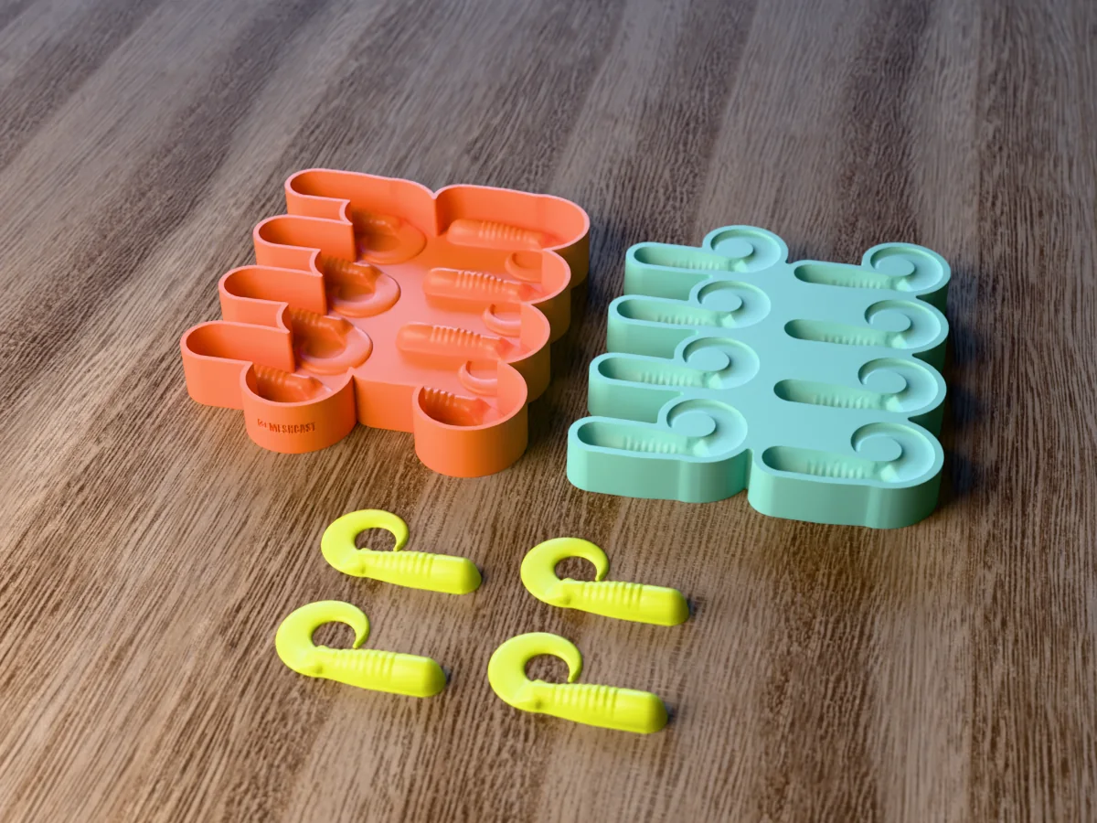 3D render of the printed caster for an eight-cavity silicone curly tail grub lure mold beside the silicone mold it pours, with chartreuse soft plastic grubs in front
