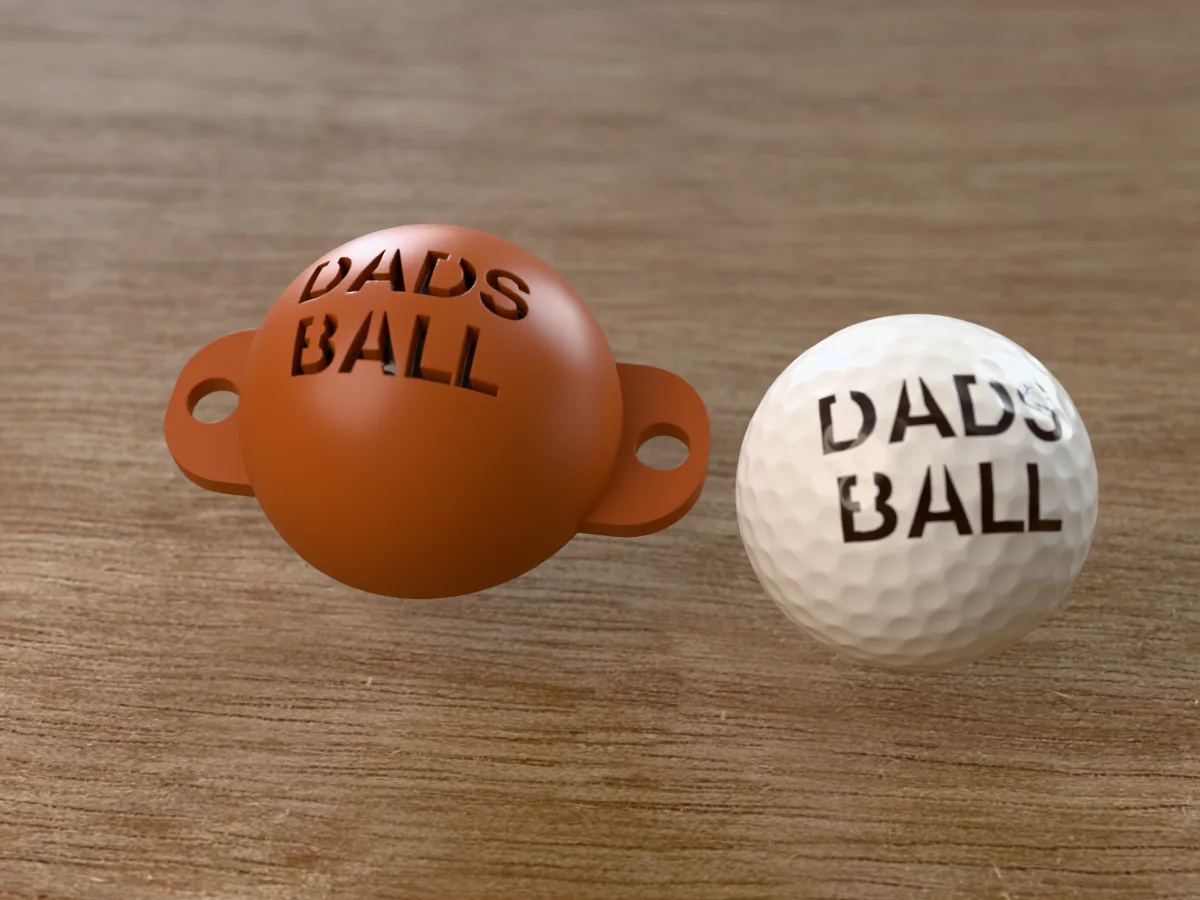 3D render of a brown 3D-printed golf ball stencil with DADS BALL cut through it, sitting on a golf ball, next to a ball marked with DADS BALL in dark brown