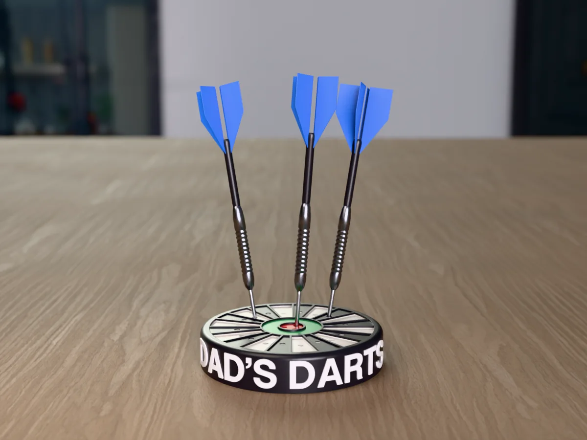 3D render, low view of the printed DAD'S DARTS dart holder on a table, the name raised in white round the black case and three darts with blue flights standing in it