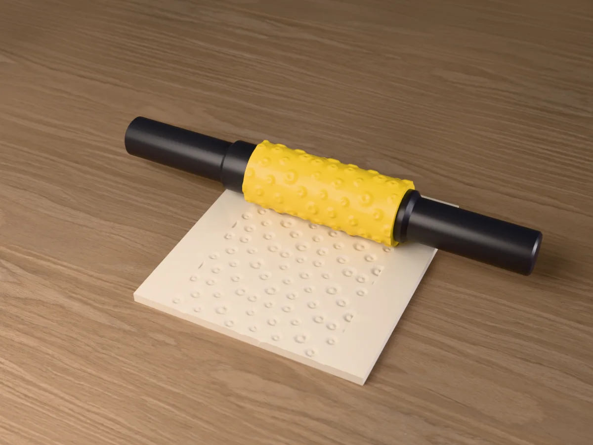 3D render of the printed daisy meadow textured rolling pin, its patterned sleeve between two dark handles, resting on a slab of clay it has pressed with a meadow of daisies