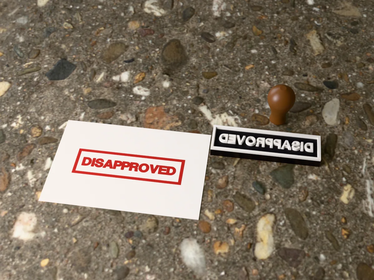 3D render of the printed disapproved stamp, face up next to its brown handle, and its red ink print on a sheet of paper