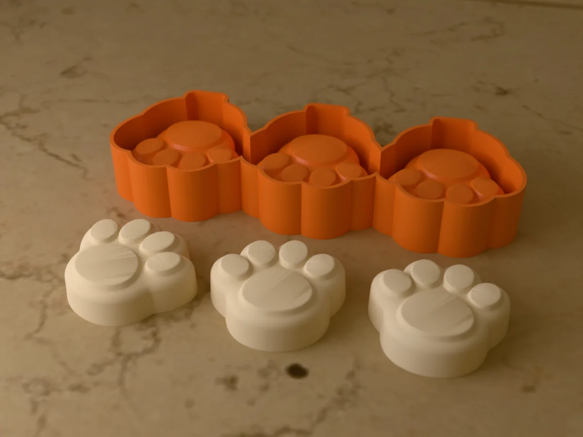 3D render of the printed caster for a three-cavity silicone dog paw popsicle mold, with three cream paw print pupsicles in front