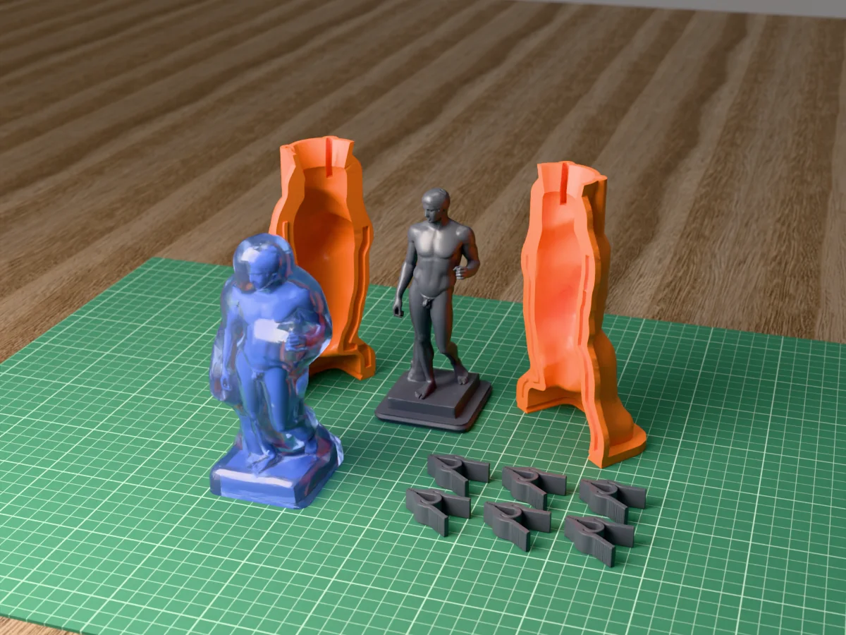 3D render of the Doryphoros master on its printed charcoal base between the two orange hugging-shell halves, with the six printed clamps and the cured translucent blue silicone mold in front