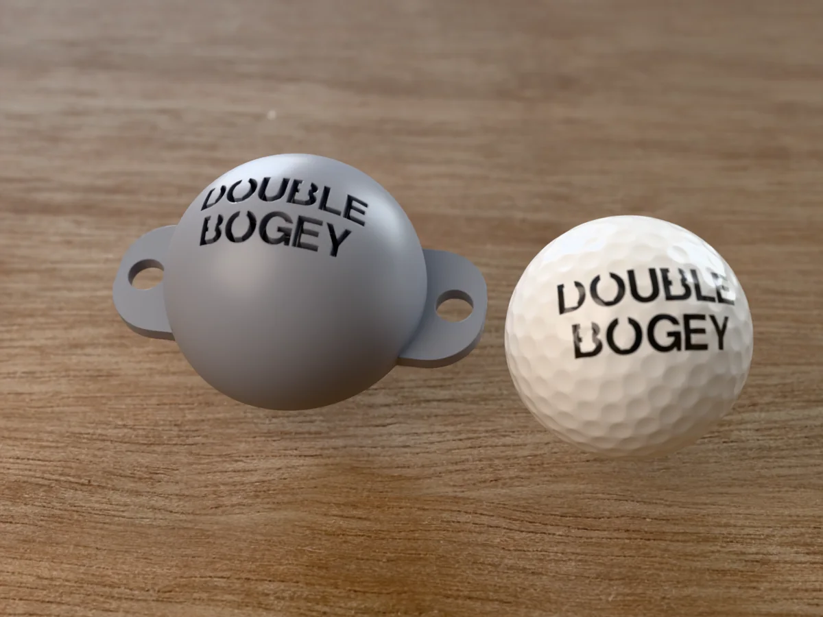 3D render of a grey 3D-printed golf ball stencil with DOUBLE BOGEY cut through it, sitting on a golf ball, next to a ball marked with DOUBLE BOGEY in black