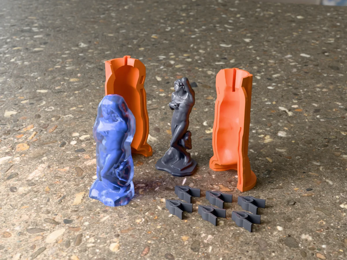 3D render of the Dying Slave master on its printed charcoal base between the two orange hugging-shell halves, with the six printed clamps and the cured translucent blue silicone mold in front