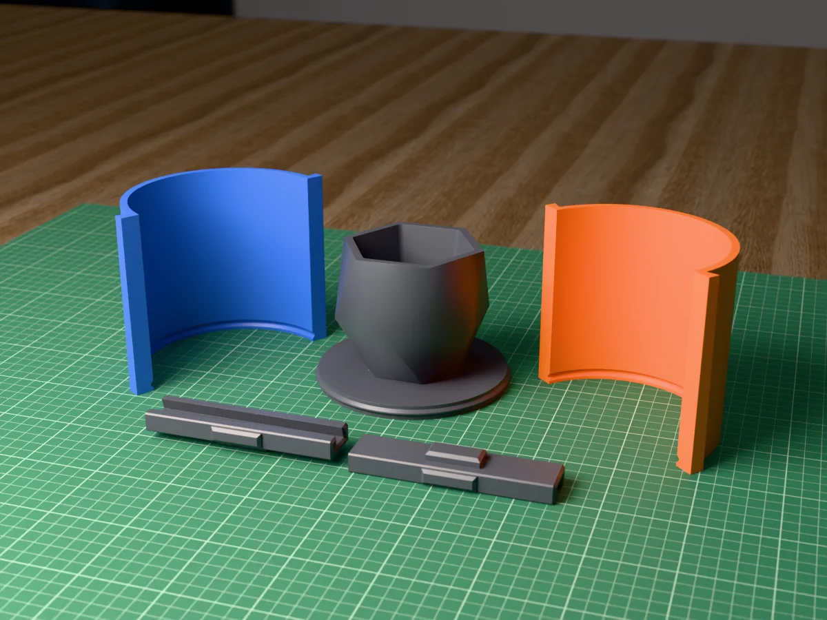 3D render of the faceted geometric planter master fused on its printed charcoal base, between the orange and blue round walls, with the charcoal clamps behind