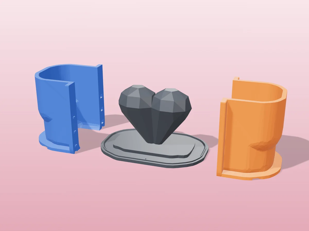 3D render of the faceted heart master fused on its printed charcoal base, between the orange and blue hugging shell halves