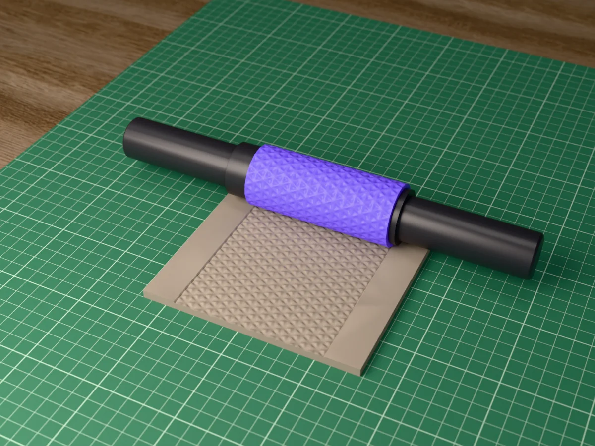 3D render of the printed faceted triangle textured rolling pin, its patterned sleeve between two dark handles, resting on a slab of clay it has pressed with faceted triangles