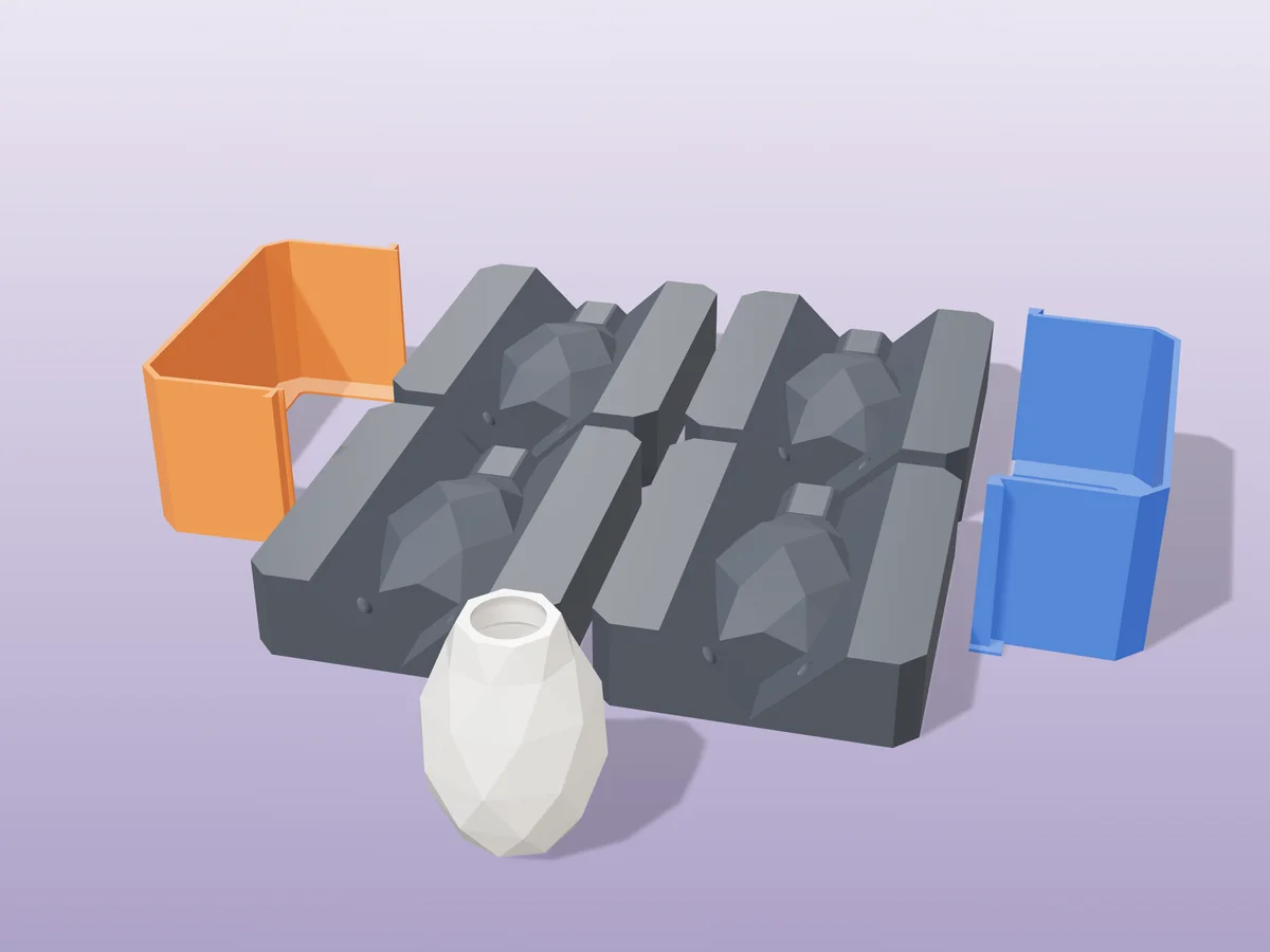 3D render of four printed plaster-mold housings for a faceted low-poly vase, orange and blue shells beside charcoal bases, with a white fired geometric vase in front