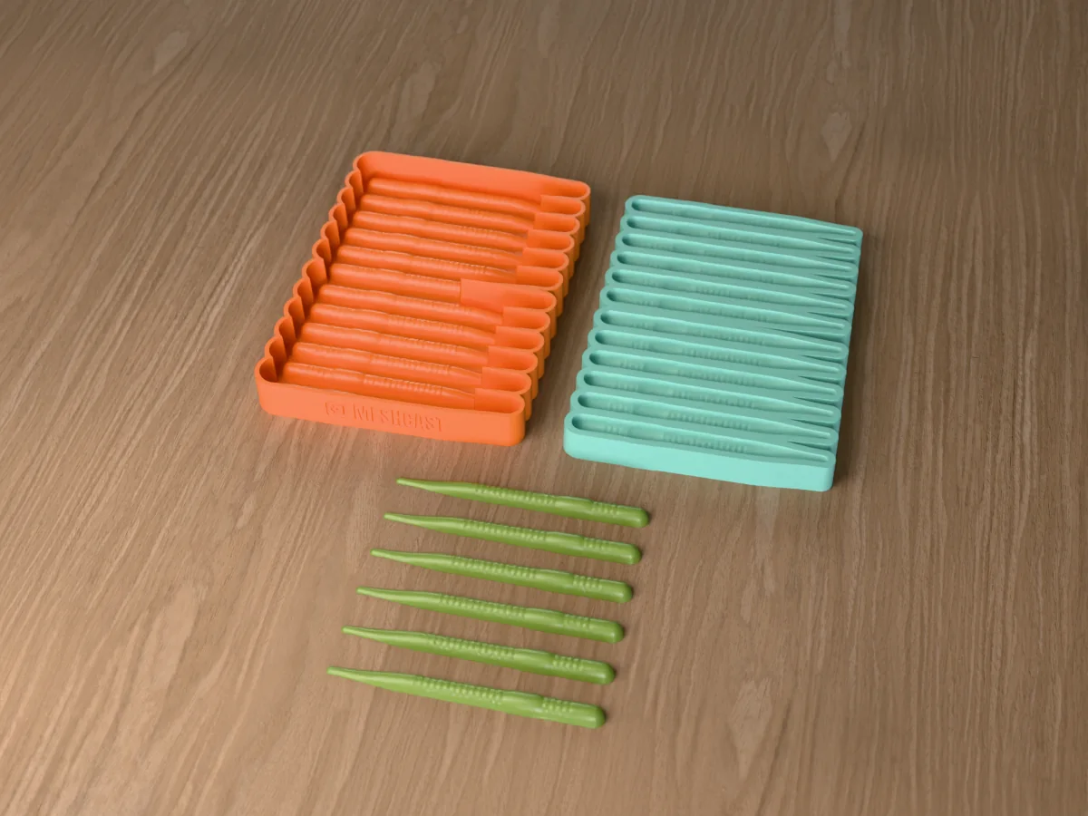 3D render of the printed caster for a twelve-cavity silicone finesse worm lure mold beside the silicone mold it pours, with watermelon green soft plastic worms in front