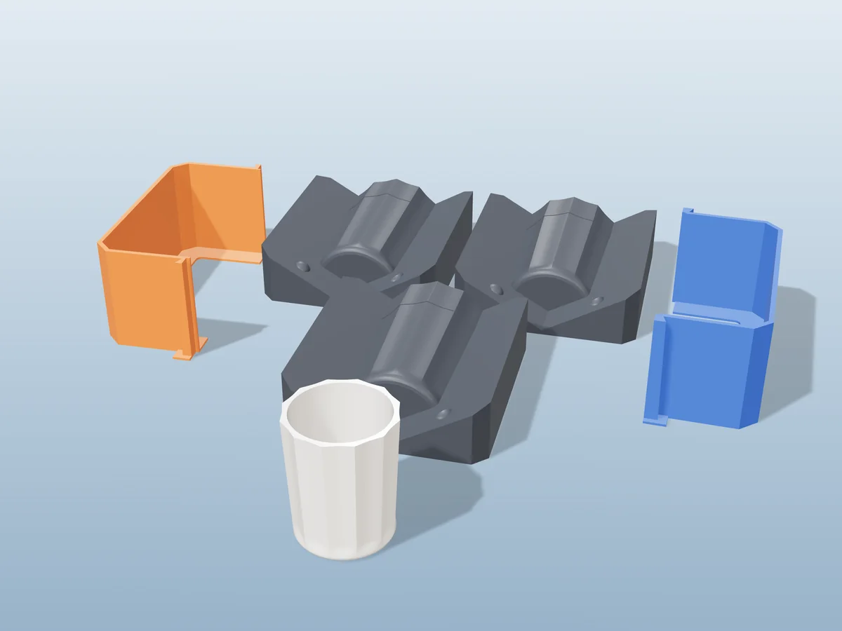 3D render of three printed plaster-mold housings for a fluted tumbler, orange and blue shells beside charcoal bases, with a white fluted fired tumbler in front