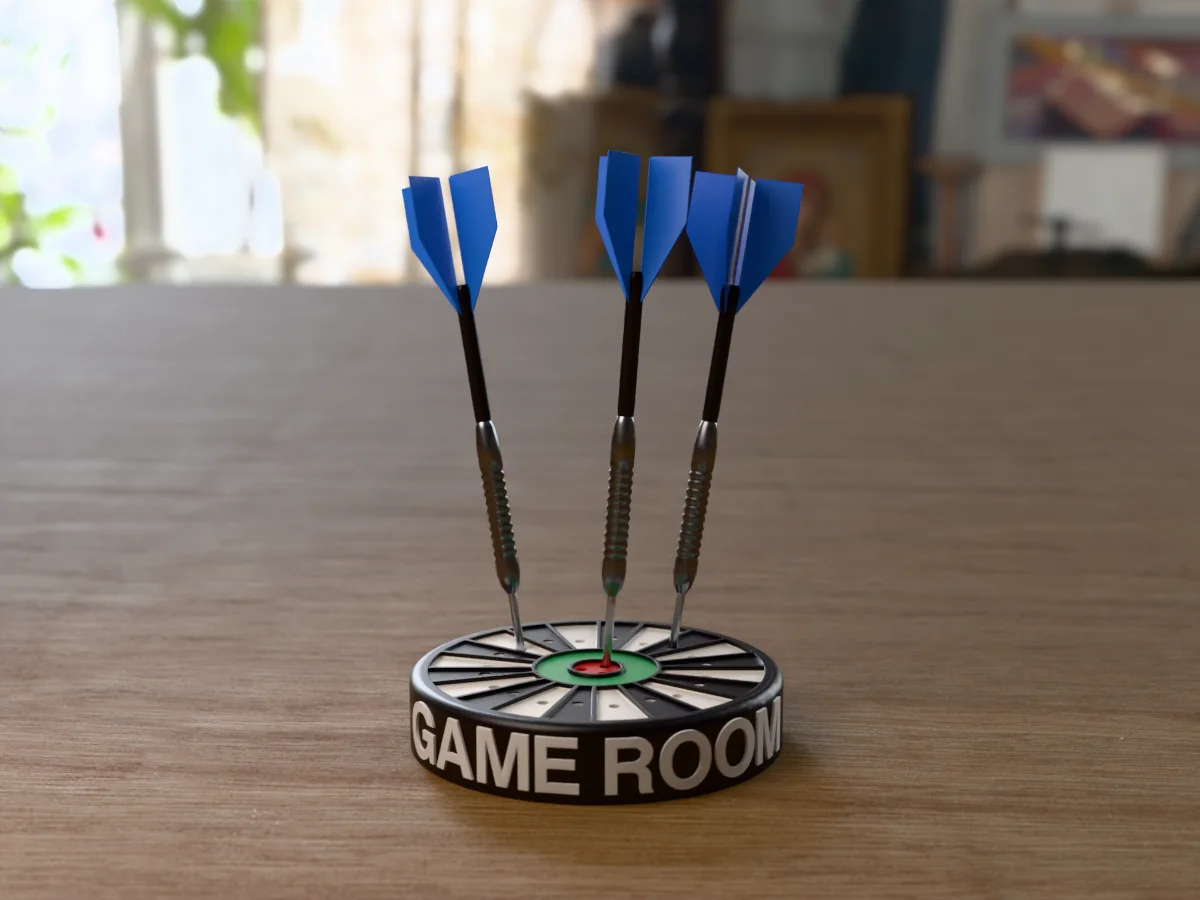 3D render, low view of the printed GAME ROOM dart holder on a table, the name raised in white round the black case and three darts with blue flights standing in it