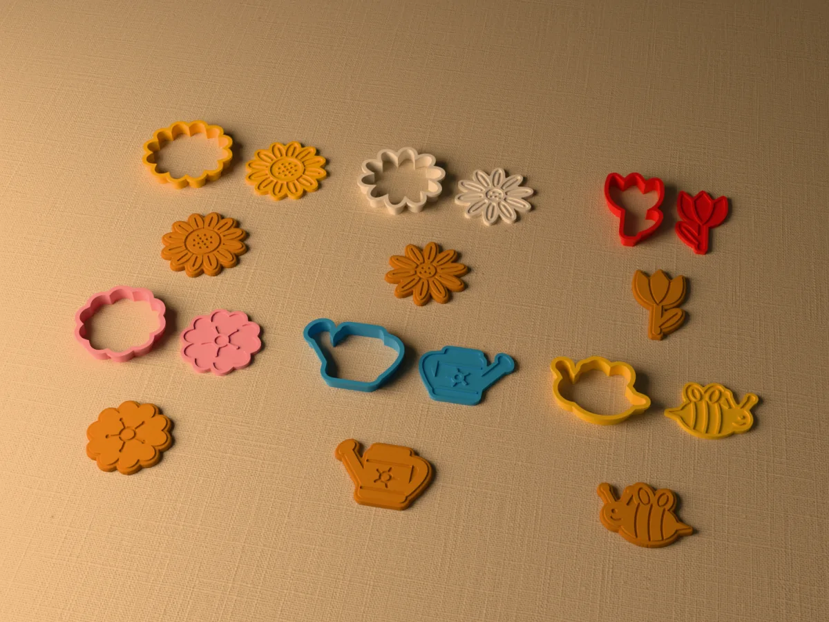 3D render of six 3D-printed garden flower cookie cutters with their stamps and a golden stamped cookie in front of each: sunflower, daisy, tulip, cherry blossom, watering can and bee
