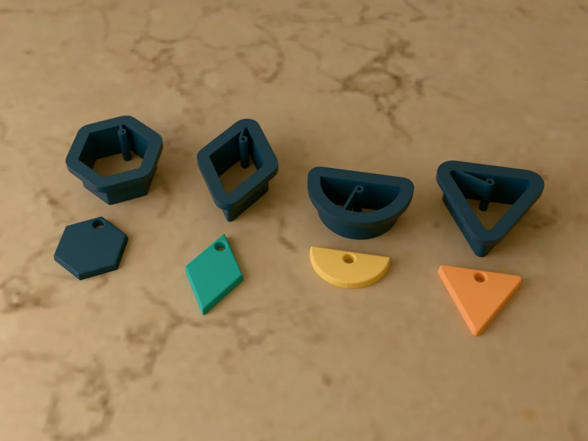 3D render of four 3D-printed dark teal polymer clay earring cutters (hexagon 26 mm, diamond 32 mm, half circle 28 mm and triangle 28 mm) with the clay earring pieces they cut in front