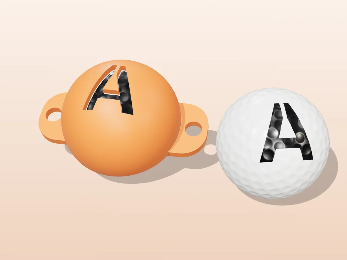 3D render of an orange 3D-printed golf ball stencil with the letter A cut through it, sitting on a golf ball, next to a ball marked with a black A