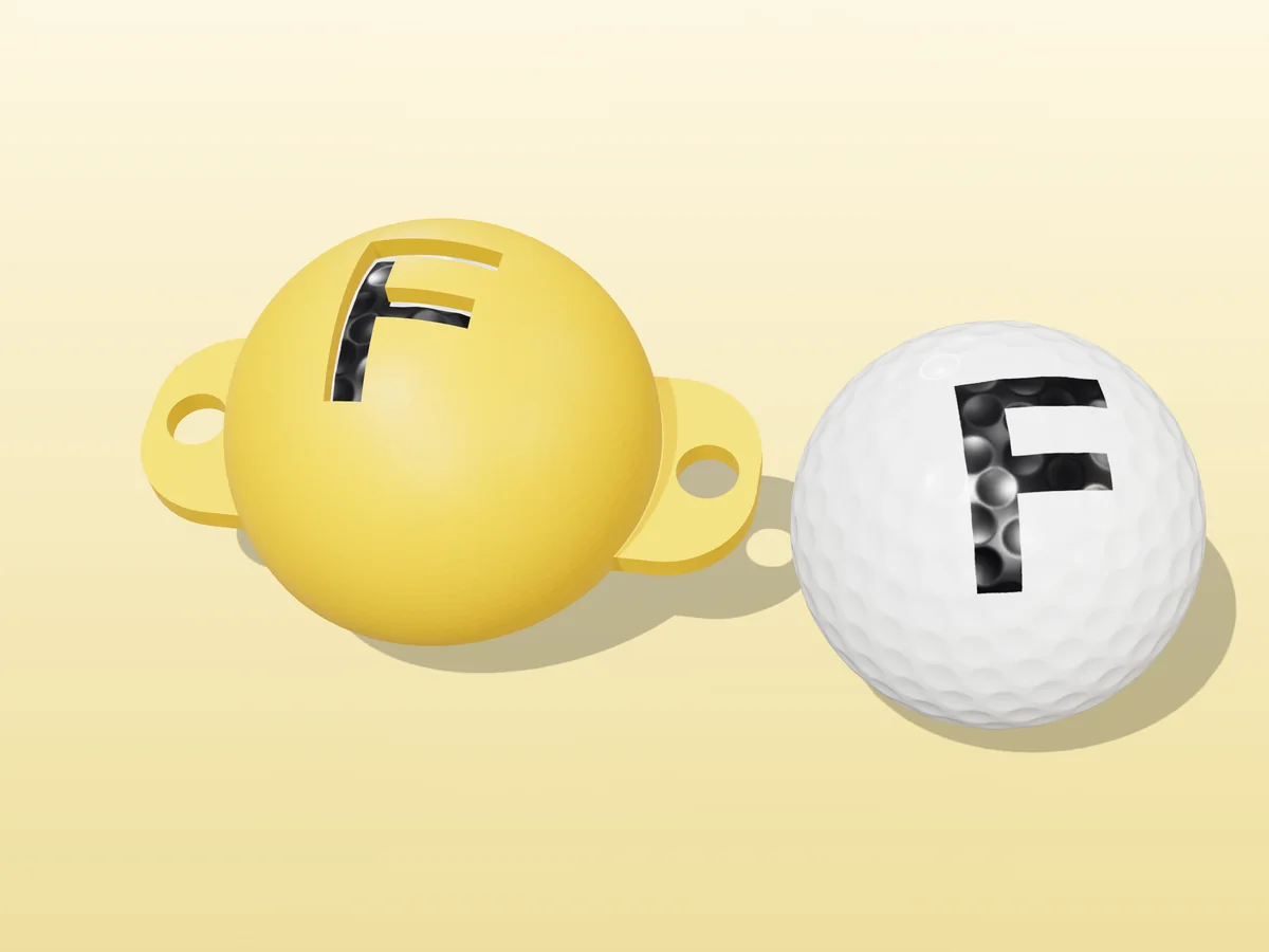3D render of a yellow 3D-printed golf ball stencil with the letter F cut through it, sitting on a golf ball, next to a ball marked with a black F