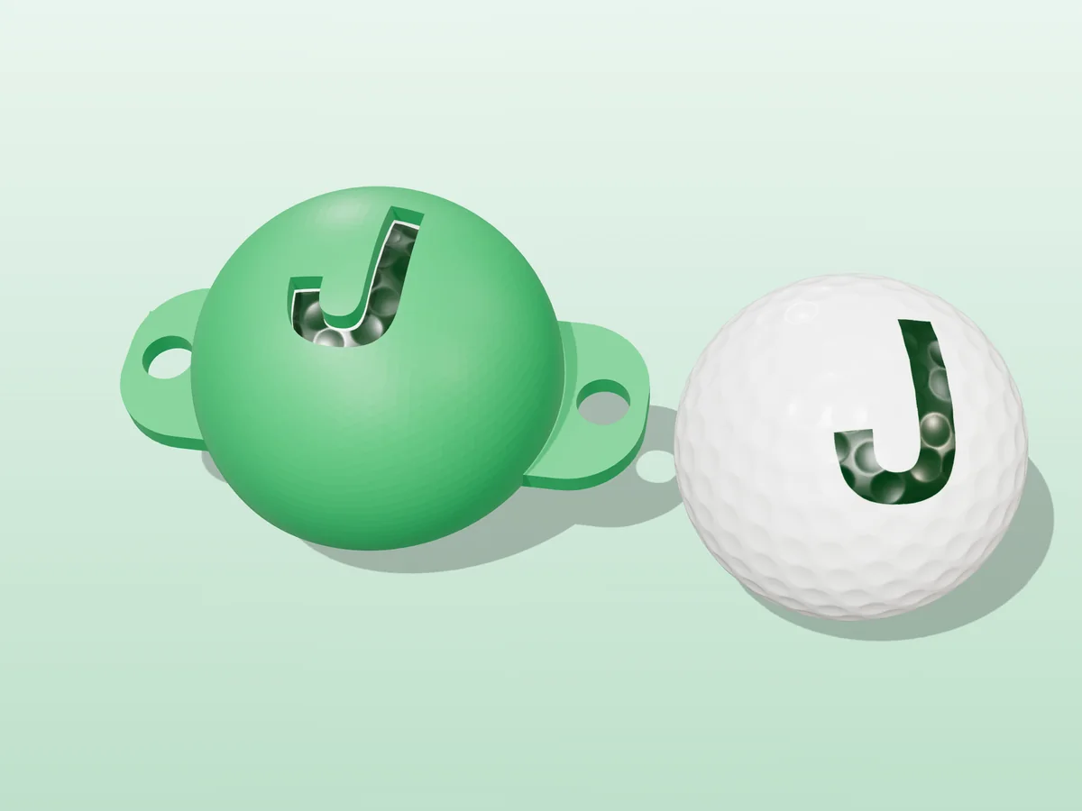 3D render of a green 3D-printed golf ball stencil with the letter J cut through it, sitting on a golf ball, next to a ball marked with a green J