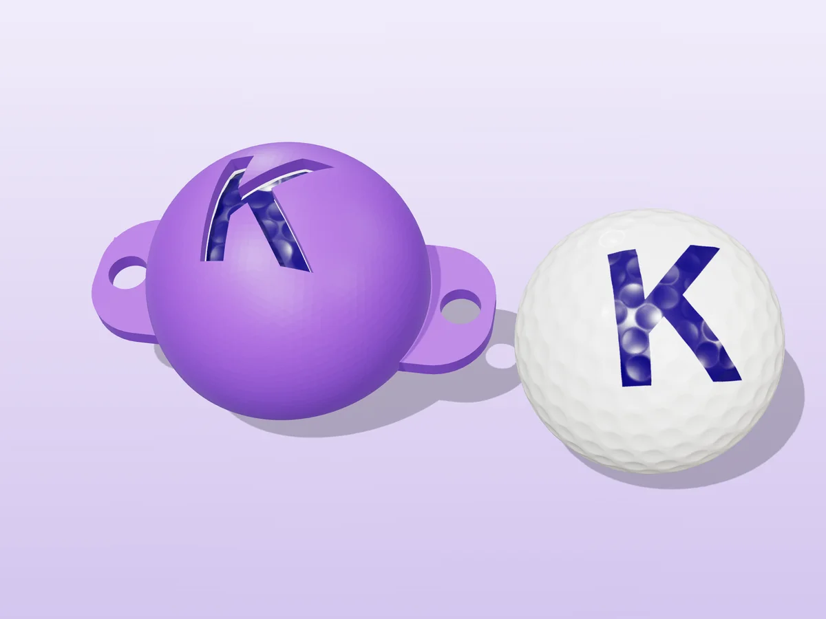 3D render of a purple 3D-printed golf ball stencil with the letter K cut through it, sitting on a golf ball, next to a ball marked with a purple K