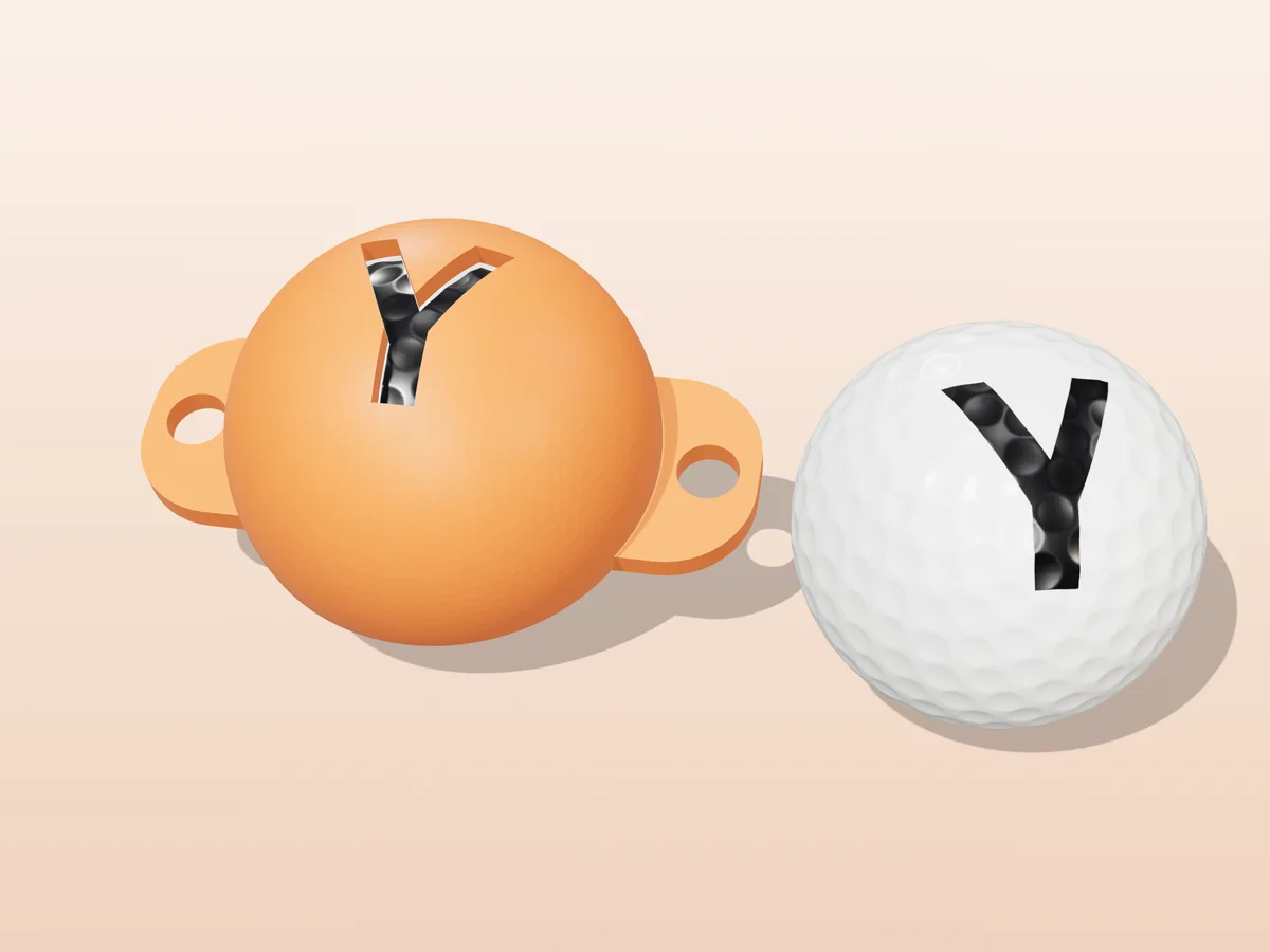 3D render of an orange 3D-printed golf ball stencil with the letter Y cut through it, sitting on a golf ball, next to a ball marked with a black Y