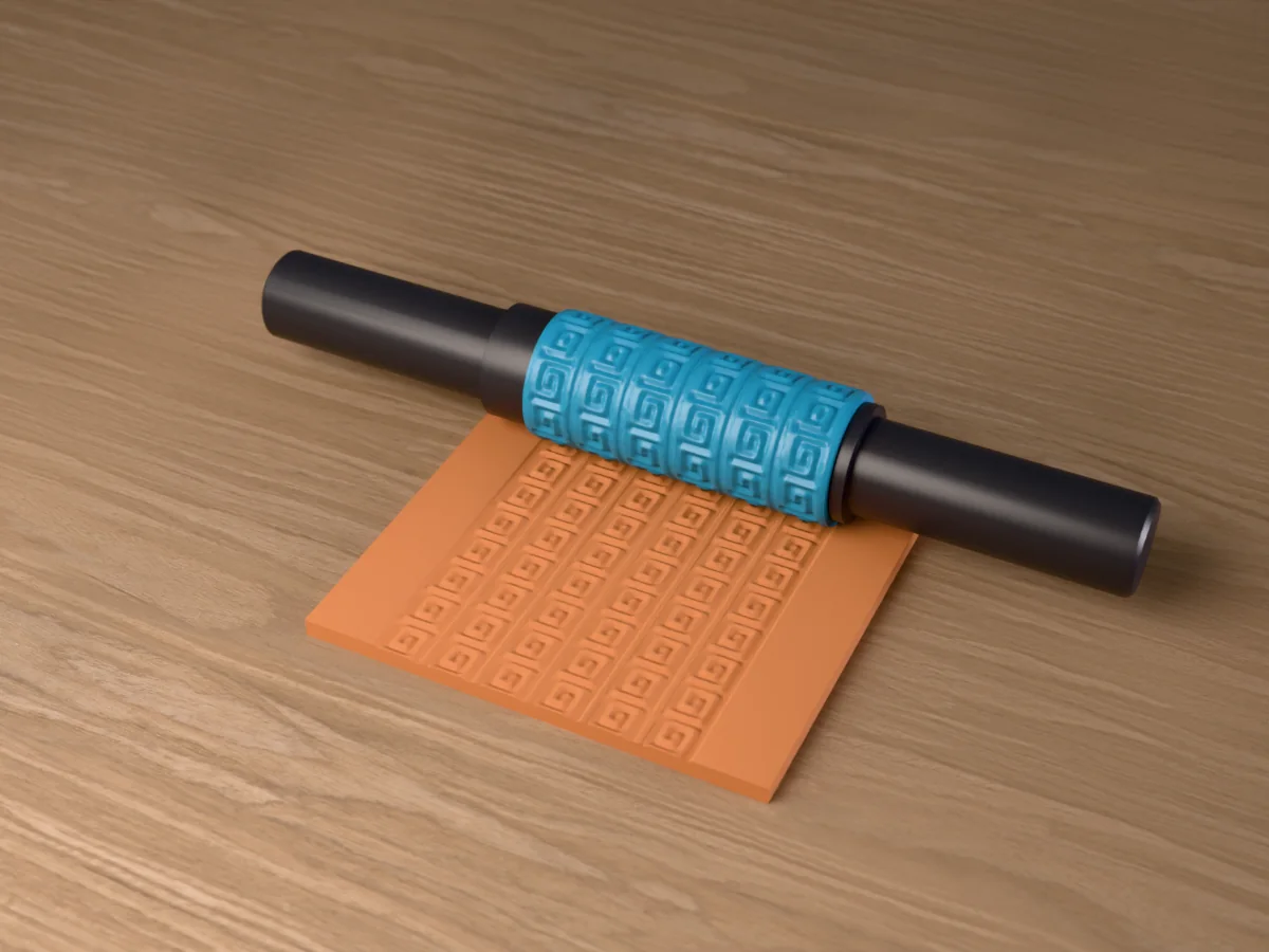 3D render of the printed greek key textured rolling pin, its patterned sleeve between two dark handles, resting on a slab of clay it has pressed with a Greek key meander