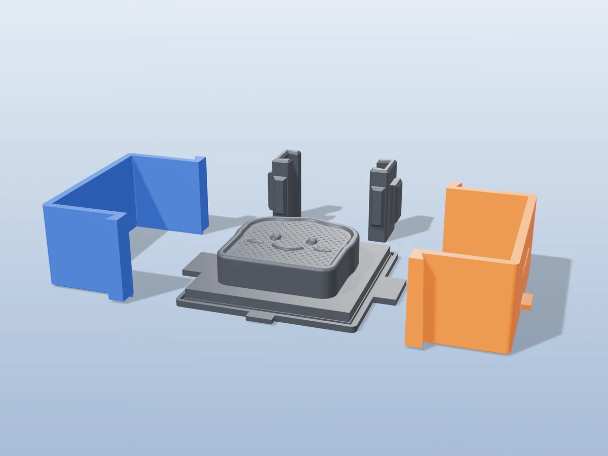 3D render of the smiling toast soap master fused on its printed charcoal base, between the orange and blue walls, with the charcoal clamps behind