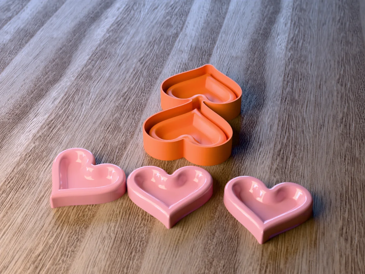 3D render of the printed caster for a two-heart silicone tray, with three blush pink heart trinket dishes in front