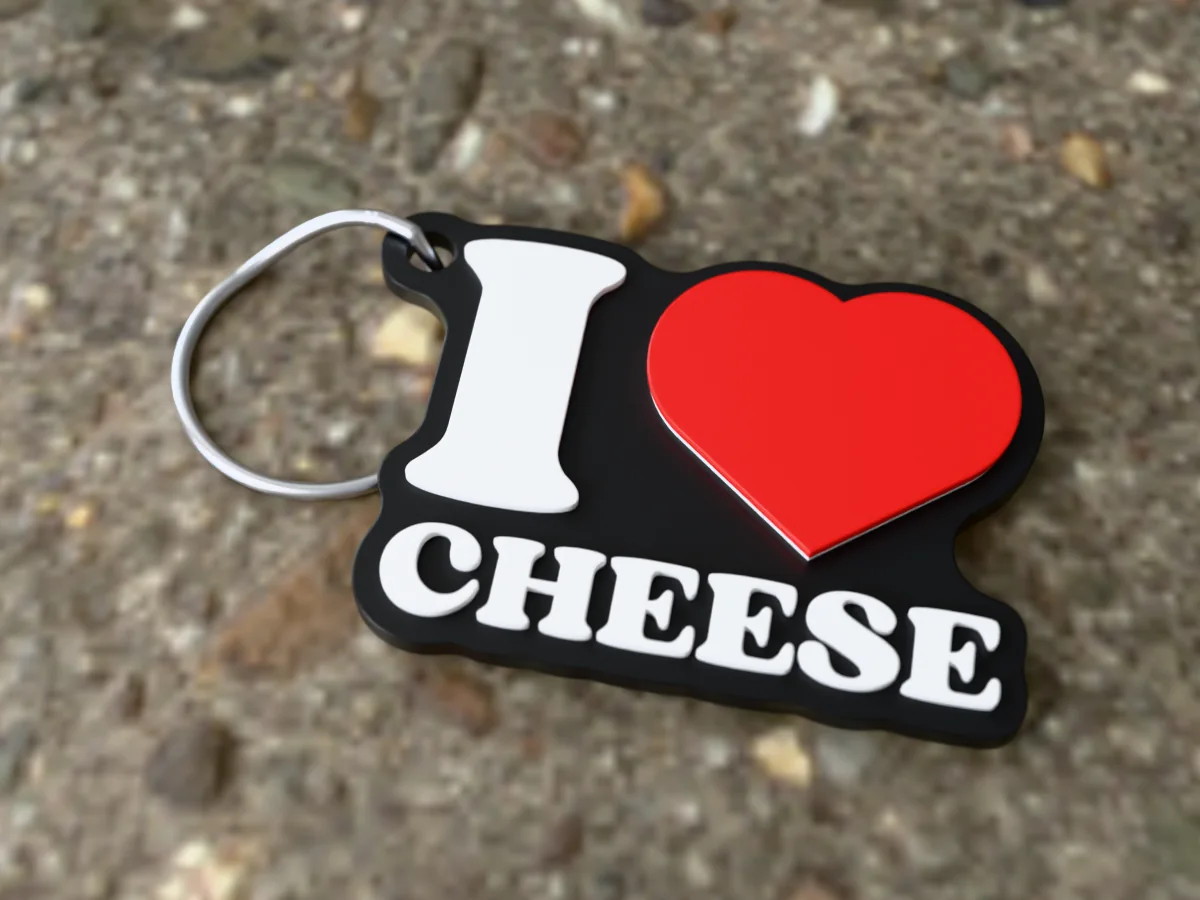 3D render of a black, white and red 3D-printed I love cheese keychain with a steel split ring through its hole