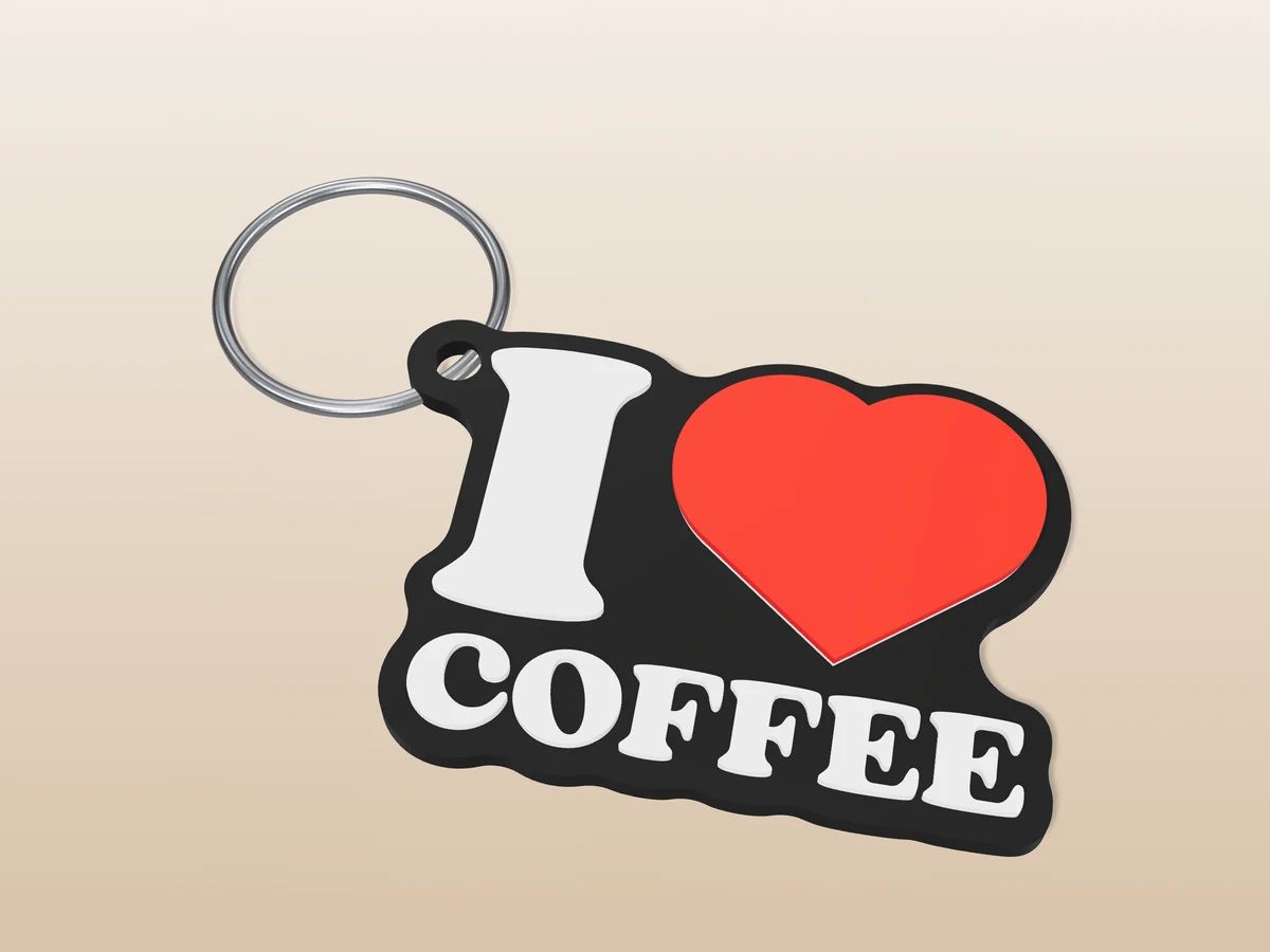 3D render of a black, white and red 3D-printed I love coffee keychain with a steel split ring through its hole