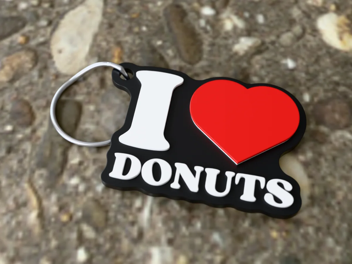 3D render of a black, white and red 3D-printed I love donuts keychain with a steel split ring through its hole