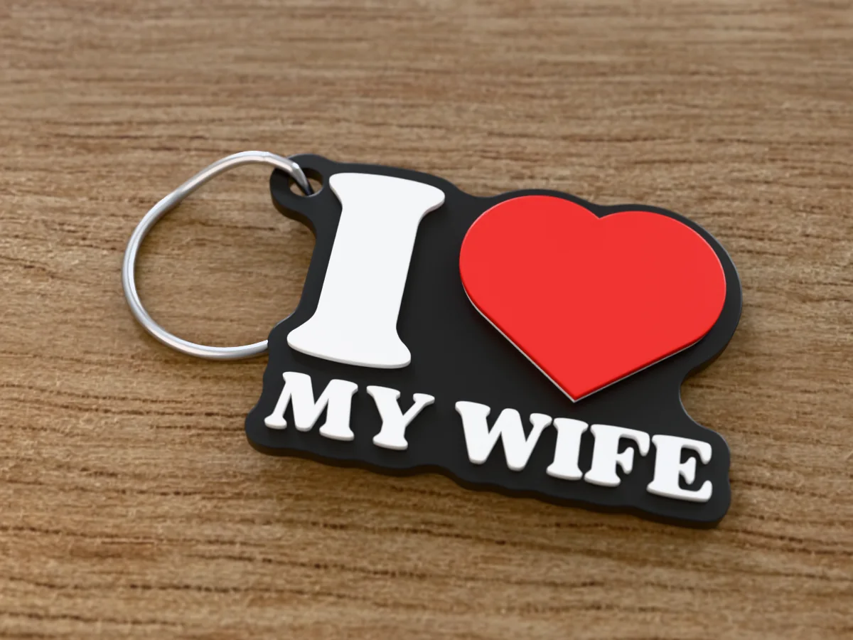 3D render of a black, white and red 3D-printed I love my wife keychain with a steel split ring through its hole